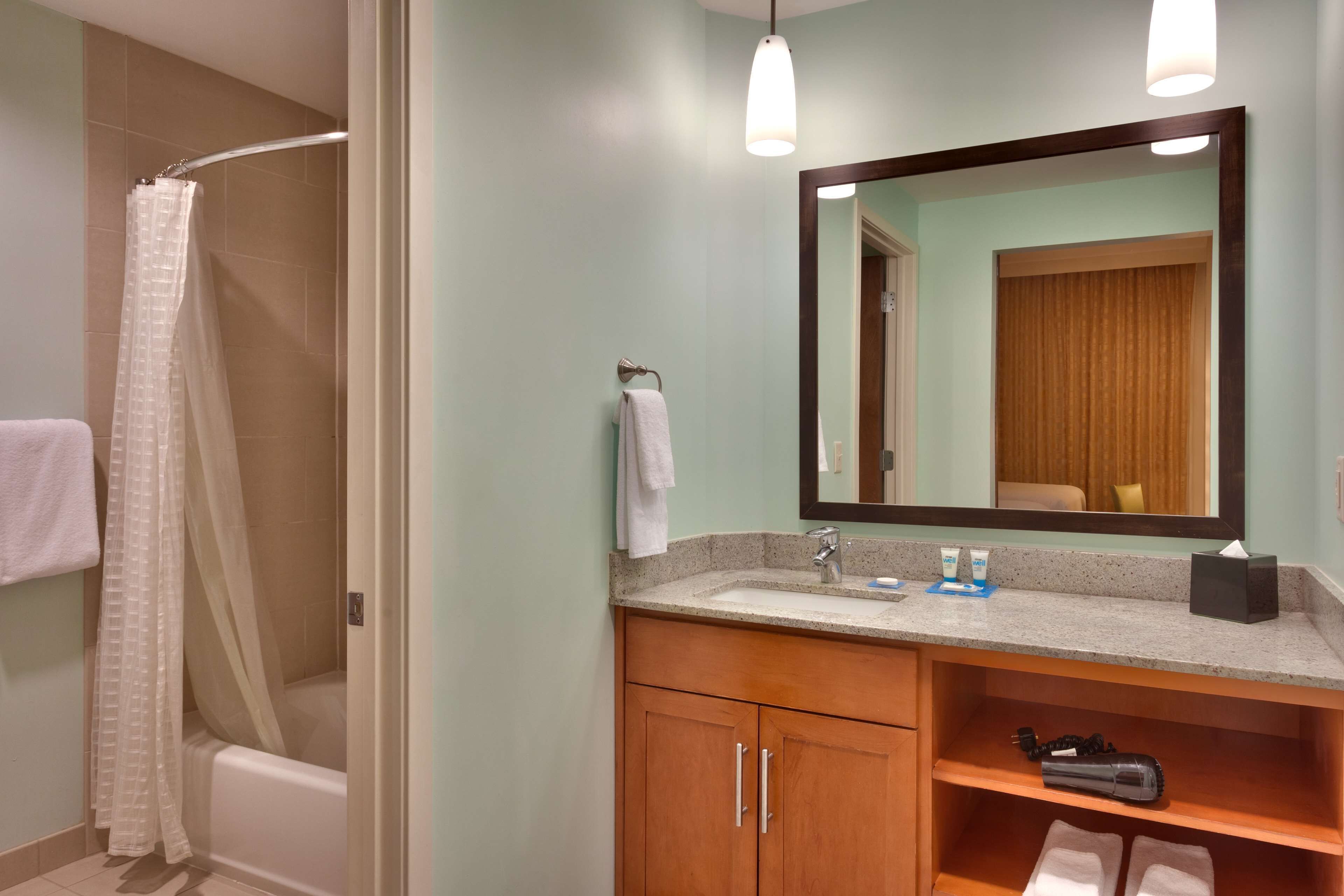 Une salle de bain avec une douche, un lavabo et un miroir.