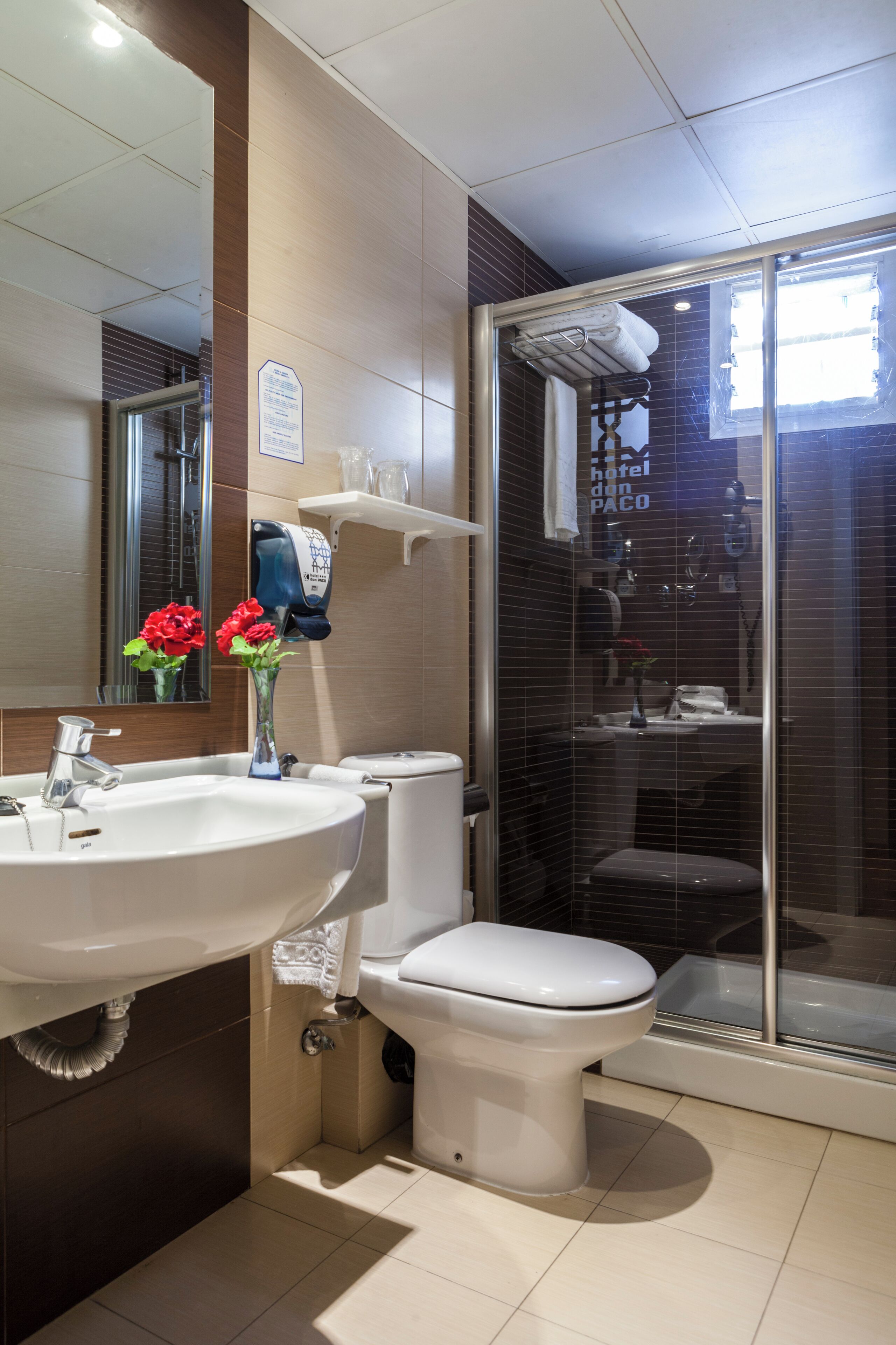Un baño moderno con lavamanos, inodoro y ducha envuelta en vidrio.