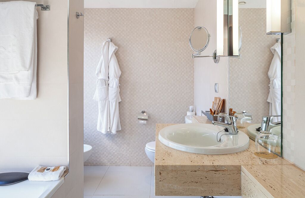 Een moderne badkamer met een ruime wastafel, een spiegel en een toilet.