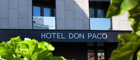 Un edificio moderno con un letrero que dice "HOTEL DON PACO".