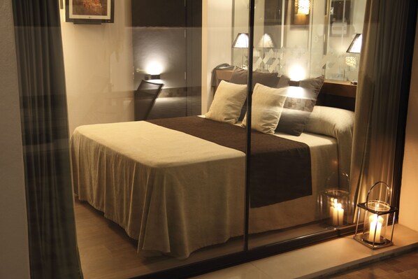 Une chambre d’hôtel avec un lit, des lampes de chevet et une table de nuit.
