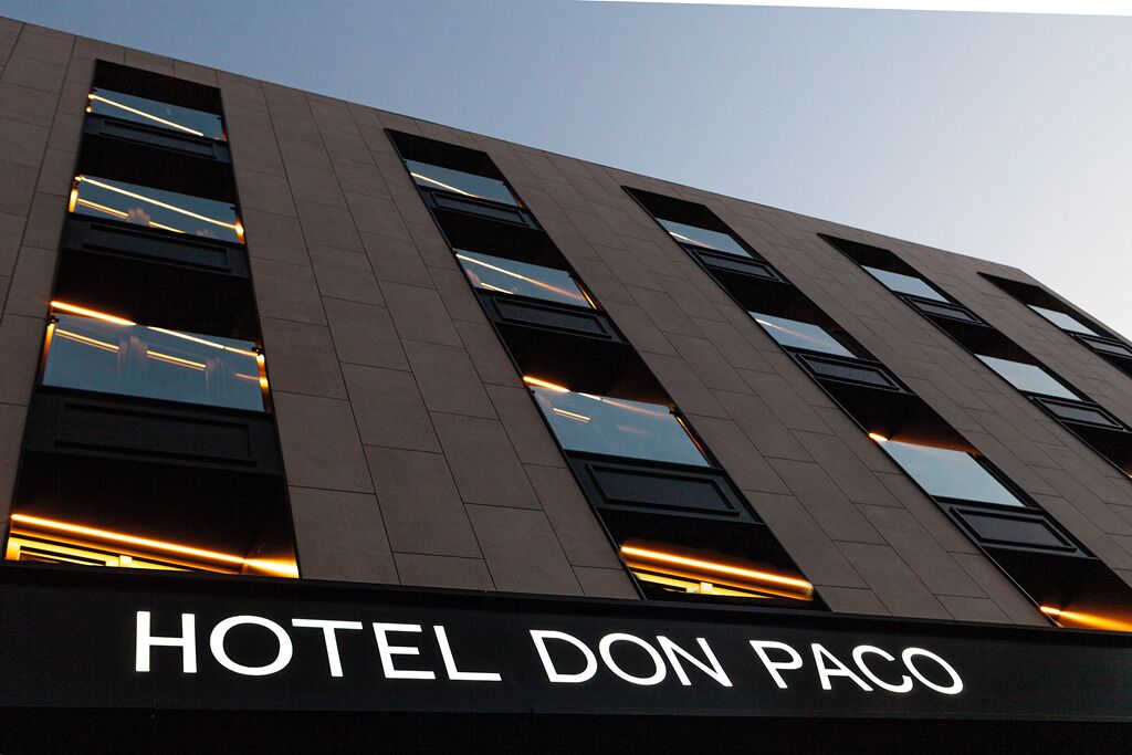 A modern building with the sign "HOTEL DON PACO" indicating a hotel establishment.