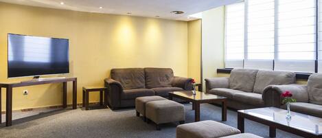 A living room with a flat-screen TV, two sofas, and a coffee table.