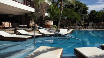 Una piscina al aire libre, sombrillas, tumbonas