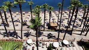 A beach resort with a swimming pool, palm trees, and a view of the sea. - Quadas Hotel - Adults Only - All inclusive (Marmaris)