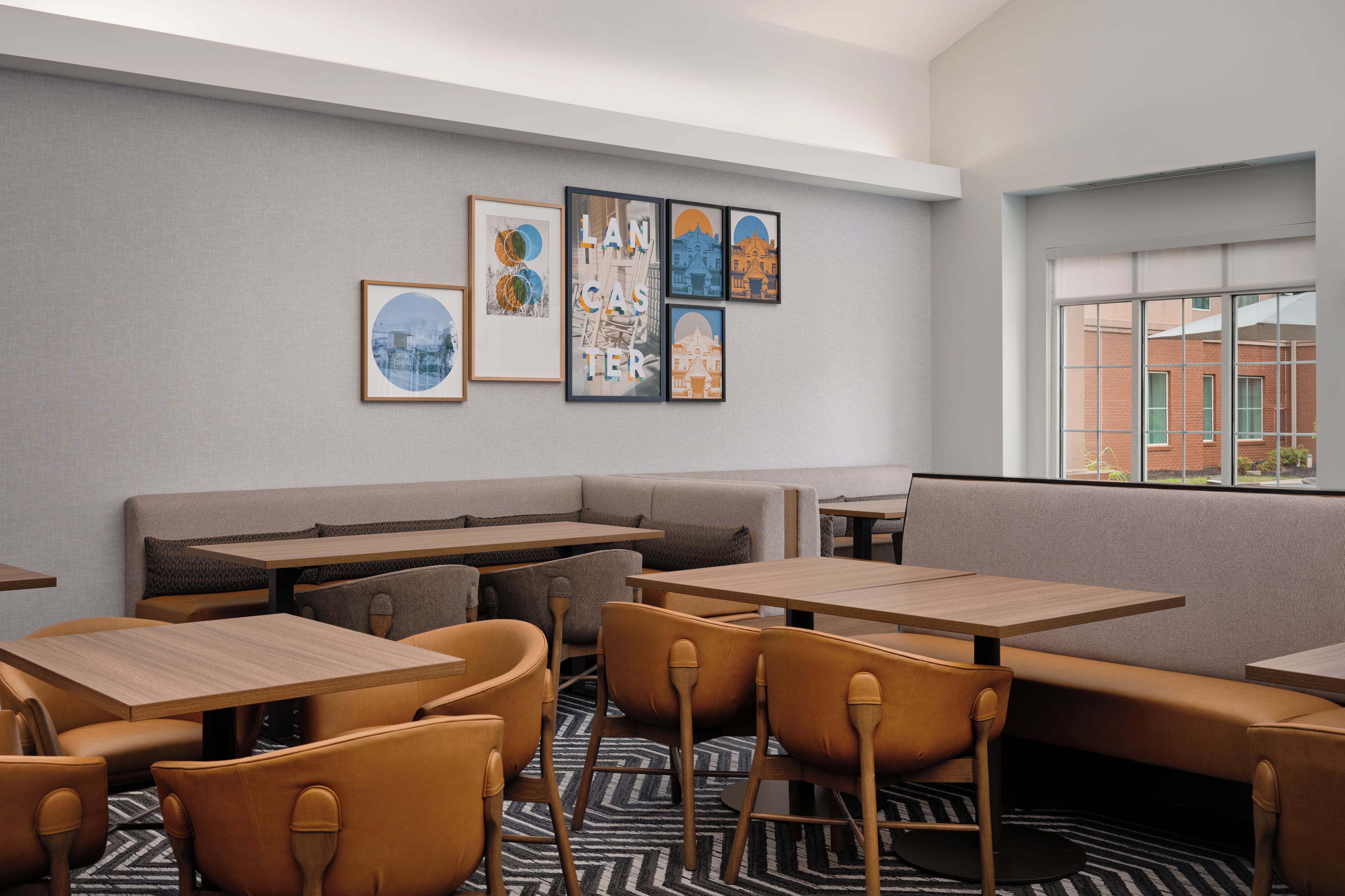 A modern interior with a seating area, tables, and artwork on the wall.