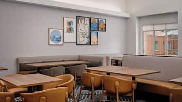 A modern interior with a seating area, tables, and artwork on the wall.