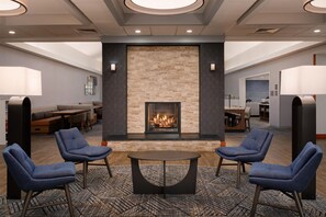 A lobby with a fireplace, seating area, and a bar. - Homewood Suites Lancaster (Lancaster)