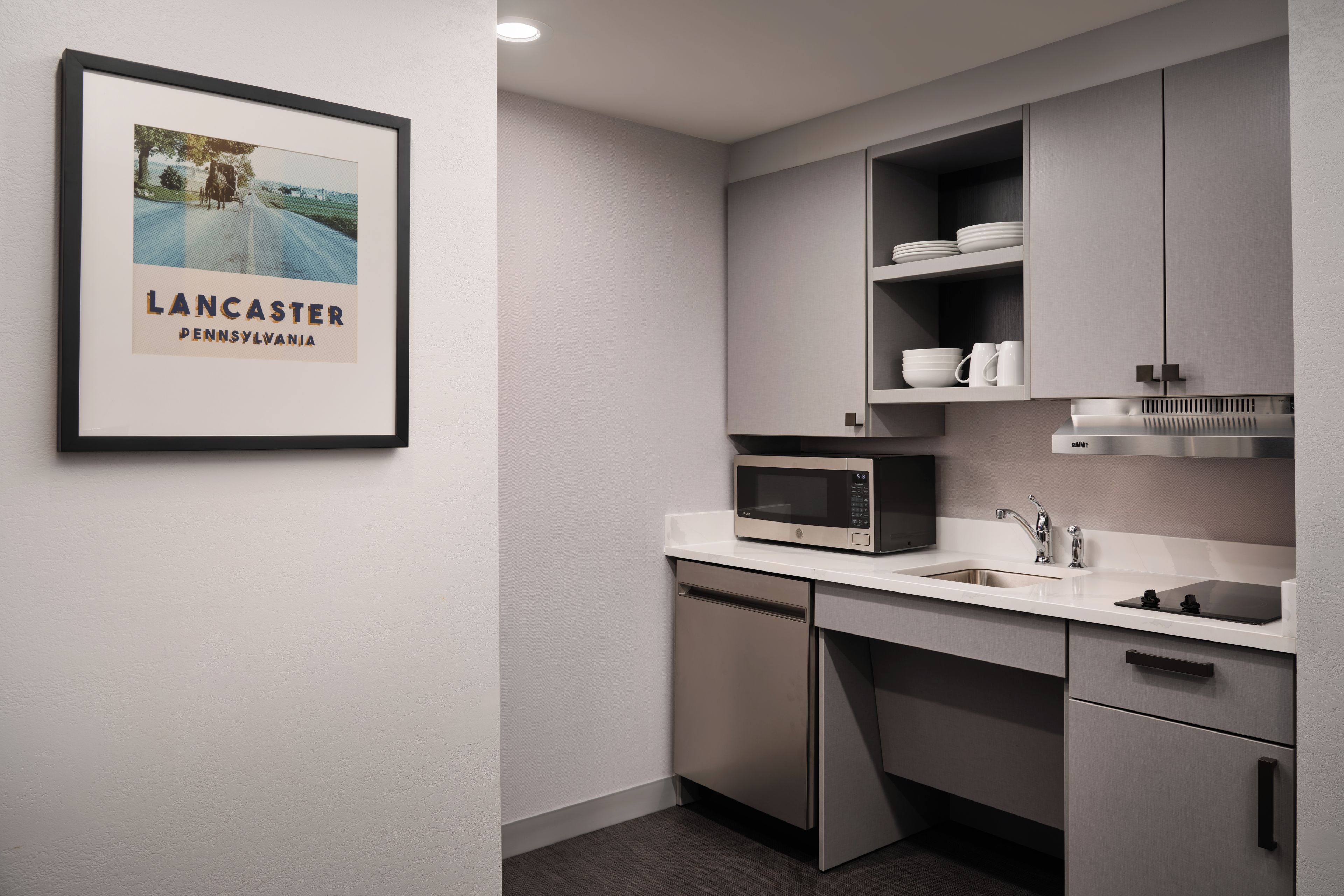 A modern kitchen with a microwave, sink, and cabinets.