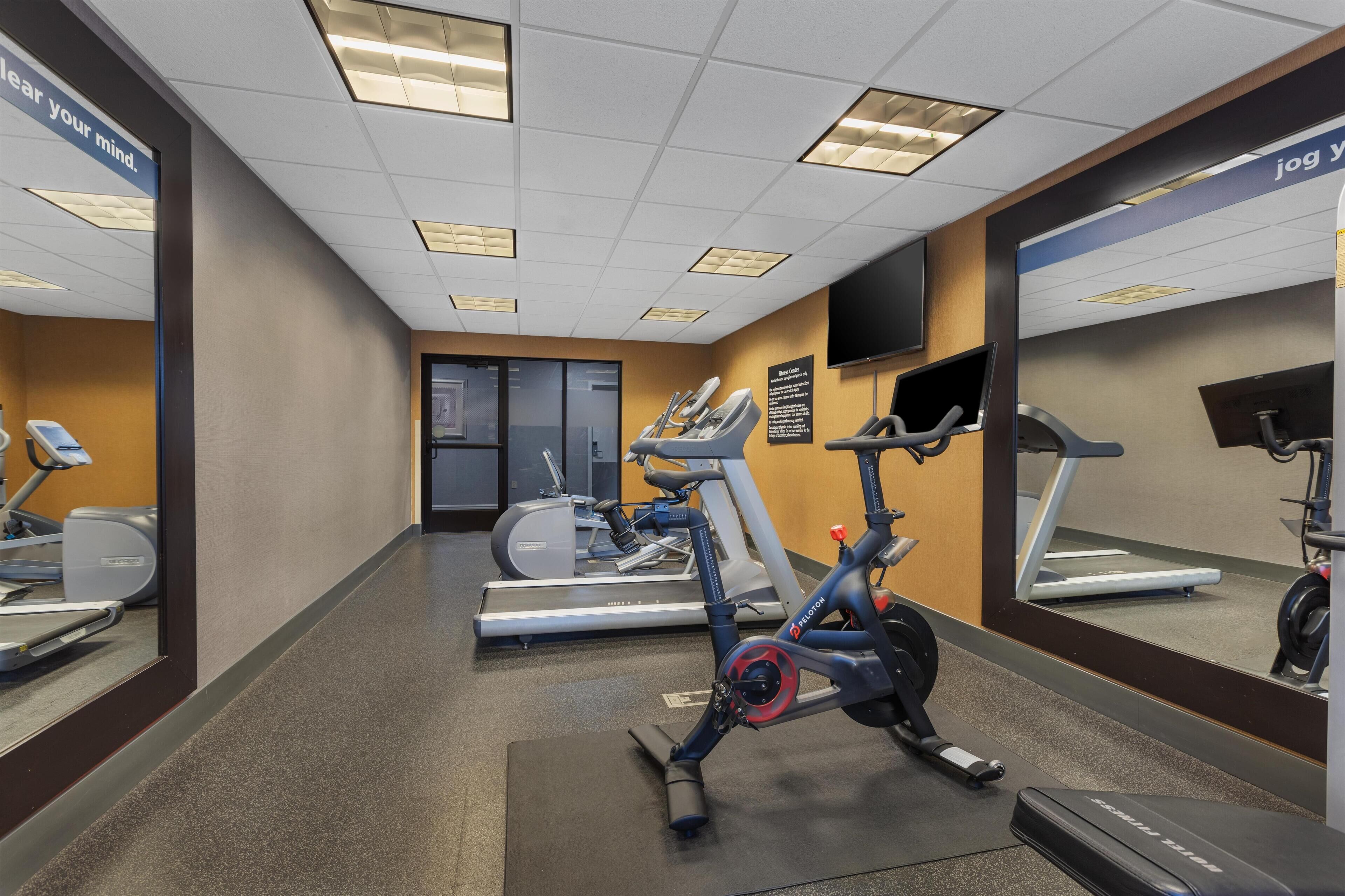 A gym with treadmills, an elliptical, and a stationary bike.