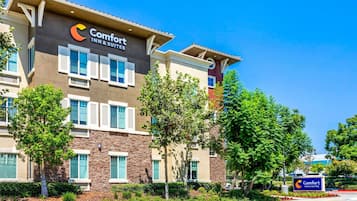 Un hôtel Comfort Inn & Suites doté d’une façade moderne, de nombreuses fenêtres et d’un parterre aménagé devant l’entrée.
