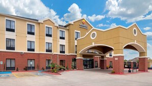 A Comfort Inn with a brick facade, multiple entry points, and a clear blue sky. - Comfort Inn & Suites Port Arthur-Port Neches (Port Arthur)