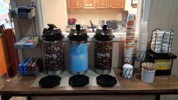 Una estación de café con tres termos etiquetados como 'Despierta': uno con granos de café descafeinado, uno con agua caliente y uno con granos de café regular.