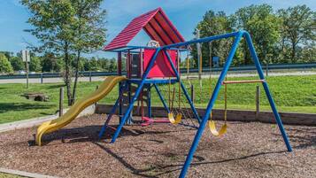 Kids can play on the slide, swings, and climbing area in this playground.