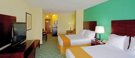 A hotel room with two beds, a television, a desk, and a chair.