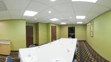 A conference room with a long table, chairs, and a podium.