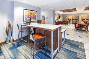 A modern hotel lobby with a reception desk, seating area, and a conference room. - Holiday Inn Express & Suites Austin NE - Hutto by IHG (Hutto)