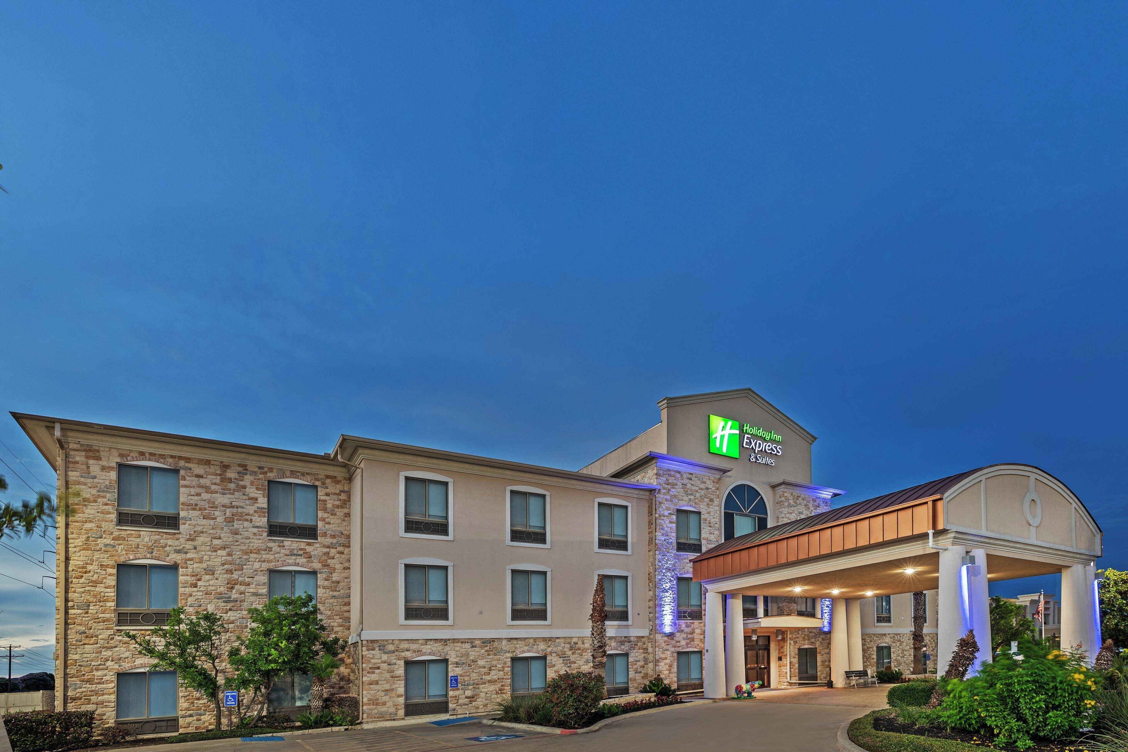 A Holiday Inn Express building with a stone facade, multiple windows, and a covered entrance.