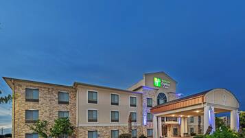 A Holiday Inn Express building with a stone facade, multiple windows, and a covered entrance.