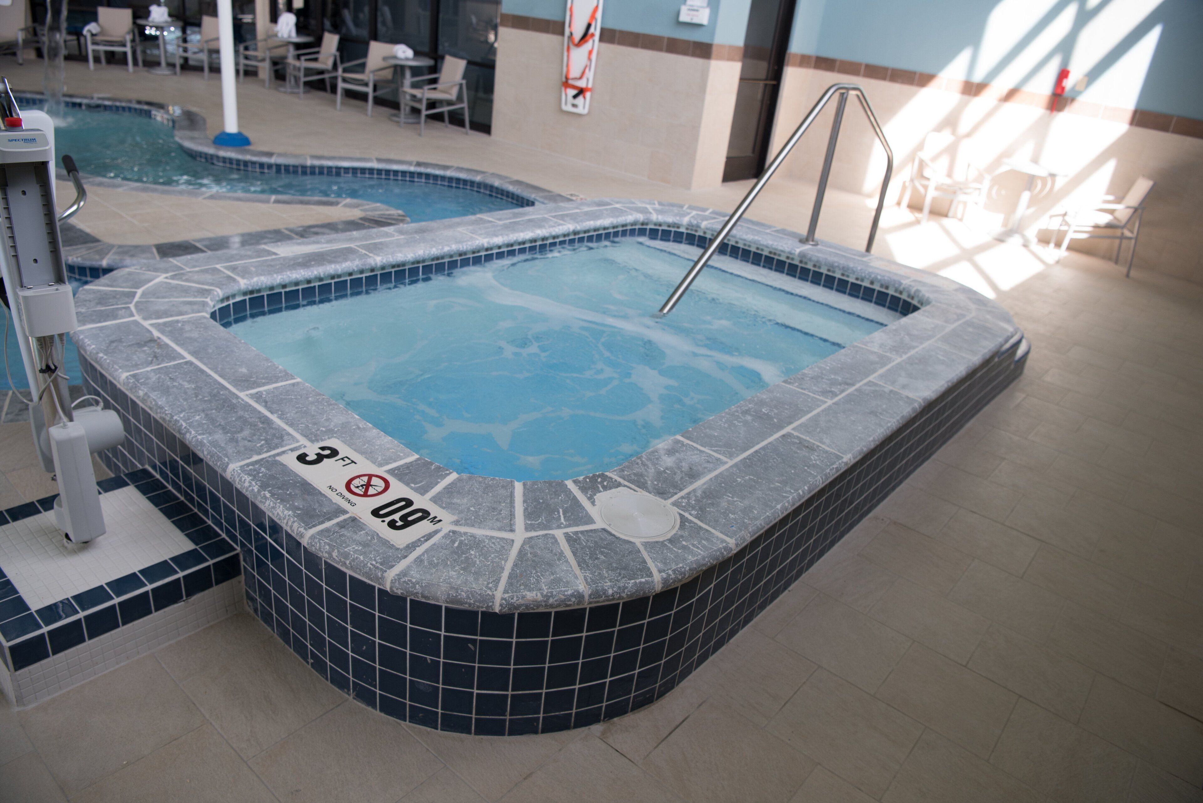 Un bain à remous avec un repère indiquant une profondeur de 3 pieds et un panneau interdisant la plongée.