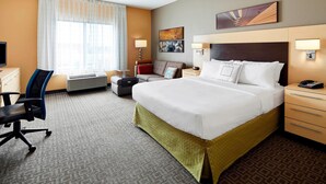 A hotel room with a large bed, a desk, a chair, a TV, and a window with curtains. - TownePlace Suites Harrisburg Hershey (Harrisburg)