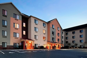 Un hôtel à plusieurs étages doté d’un parking, d’une entrée accessible et d’un passage couvert.