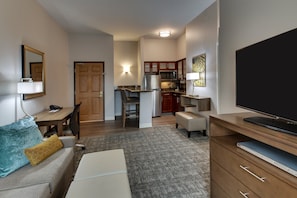 A compact living space with a kitchenette, a sofa, a TV, and a desk. - Staybridge Suites Missoula by IHG (Missoula)