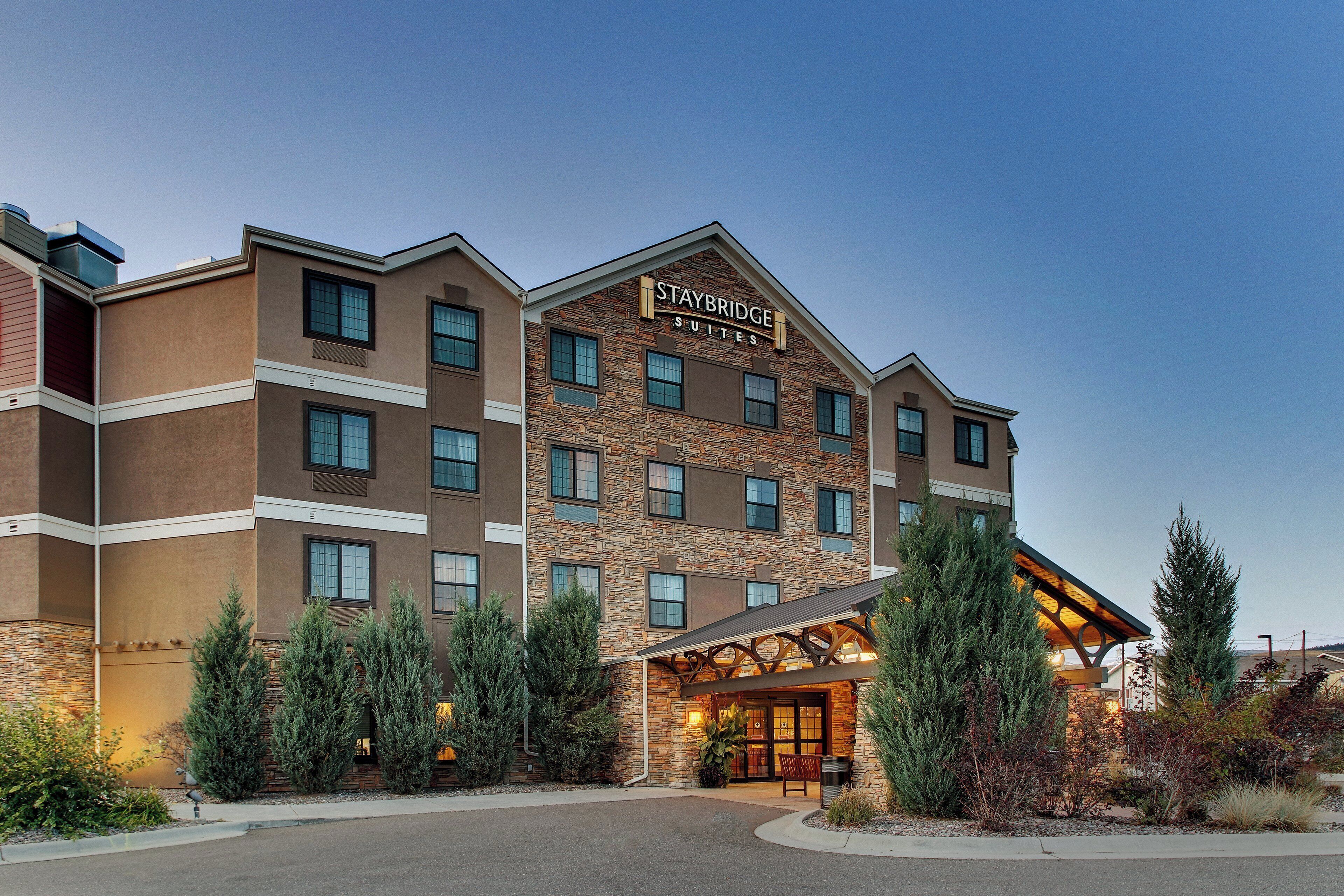 A multi-story hotel with a stone facade and a sign indicating it offers suites.