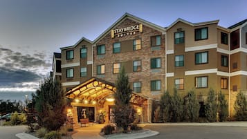 A multi-story hotel with a stone facade and a covered entrance area.