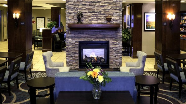 A lobby with a stone fireplace, seating area, and a reception desk. - Staybridge Suites Denver International Airport by IHG (Denver)