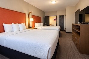 A hotel room with two beds, a desk, a dresser, and a television. - La Quinta Inn & Suites by Wyndham Augusta/Fort Eisenhower (Augusta)