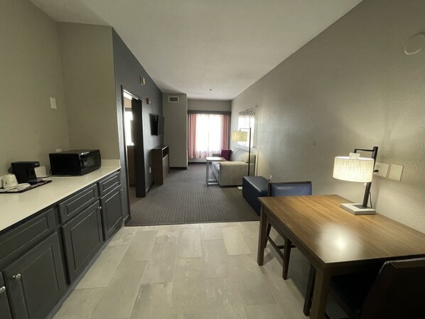 A compact hotel room with a kitchenette, a dining area, and a living space. - La Quinta Inn & Suites by Wyndham Augusta/Fort Eisenhower (Augusta)