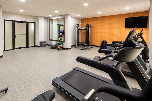 A gym with treadmills, a wall-mounted TV, and exercise equipment. - La Quinta Inn & Suites by Wyndham Augusta/Fort Eisenhower (Augusta)