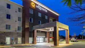Un hôtel reconnaissable à son grand panneau « LaQuinta », à son entrée abritée et à son parking.