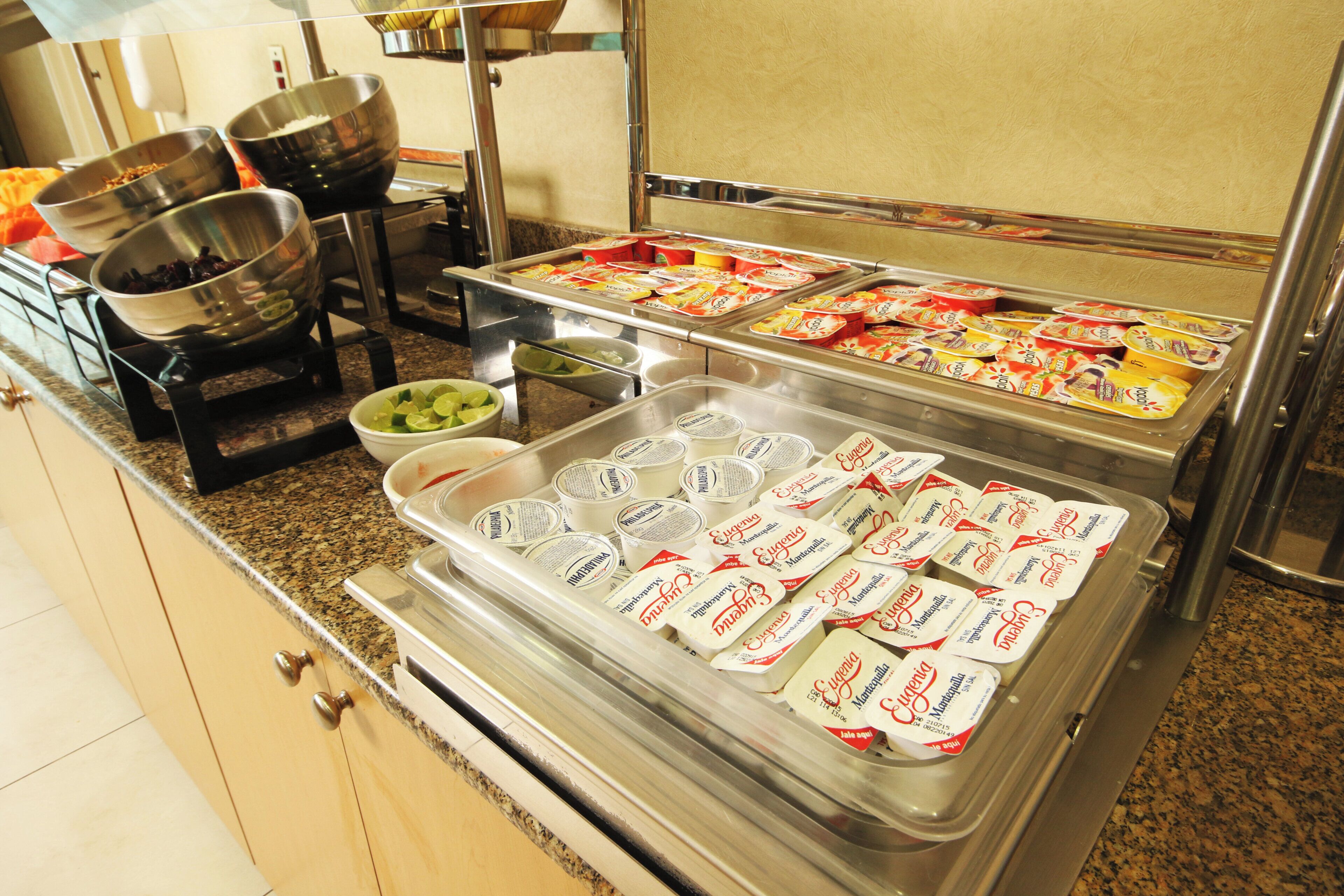 A buffet setup with various food items and containers.
