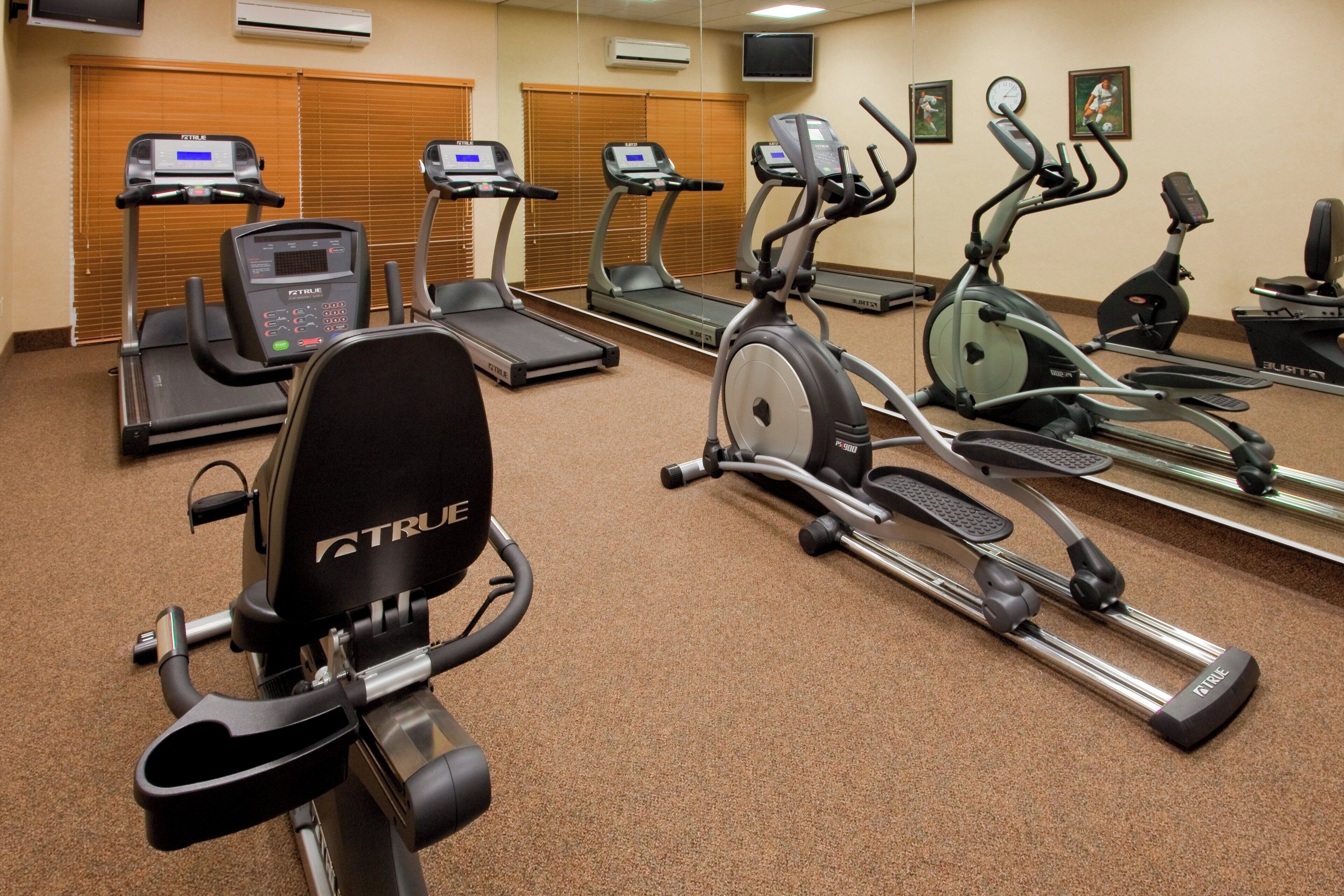 A fitness center with multiple exercise machines including treadmills and stationary bikes.