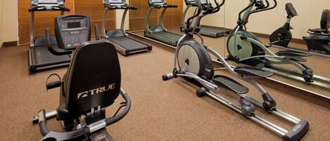 A fitness center with multiple exercise machines including treadmills and stationary bikes.
