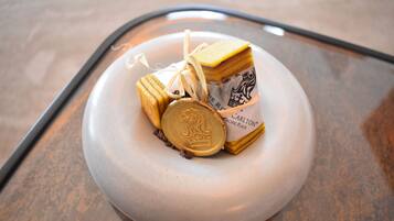 A round, white table with a stack of rectangular, layered items tied with a string, and a round, flat object with a logo.