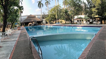 Una piscina al aire libre, sombrillas