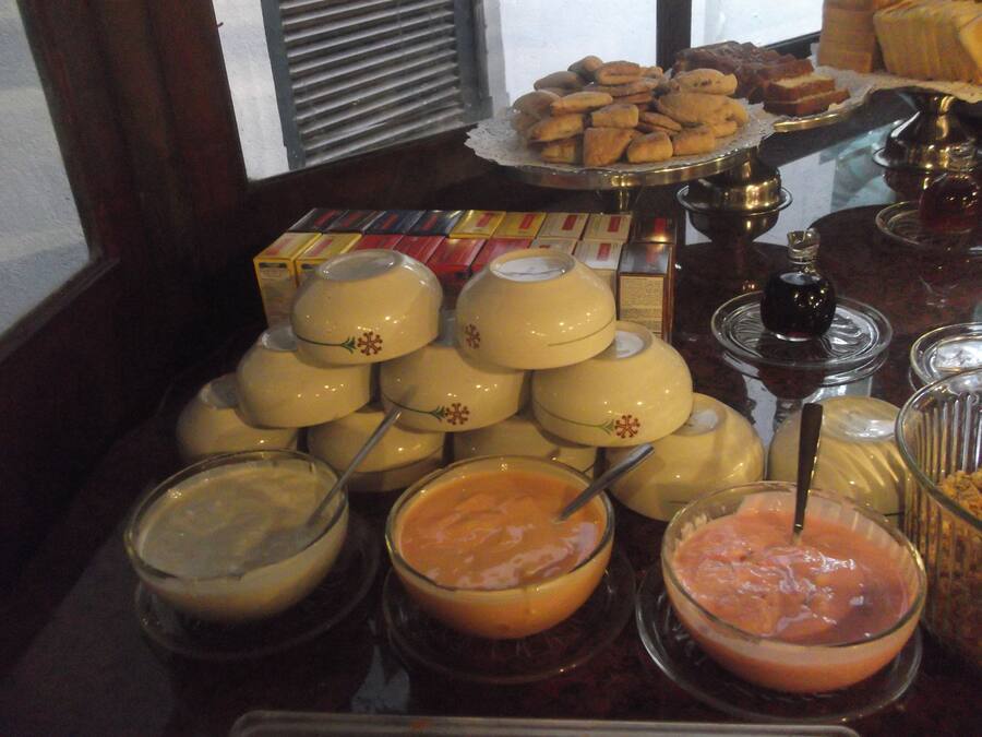 Une table de buffet proposant divers plats, notamment des bols de soupe et un plateau de pâtisseries.