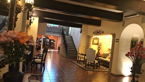 A spacious lobby with a tiled floor, a staircase, and a seating area with chairs and a sofa. - Hotel Valles (Ciudad Valles)