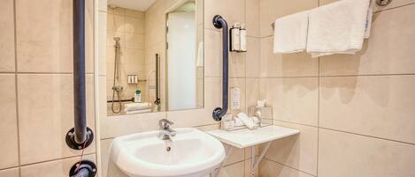A modern bathroom with a white sink, a mirror, and a towel rack.