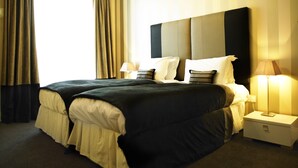 Un lit double avec une tête de lit, deux tables de chevet et une lampe de chaque côté.