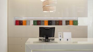 Una reception con uno schermo piatto, una lampada e uno scaffale con libri.