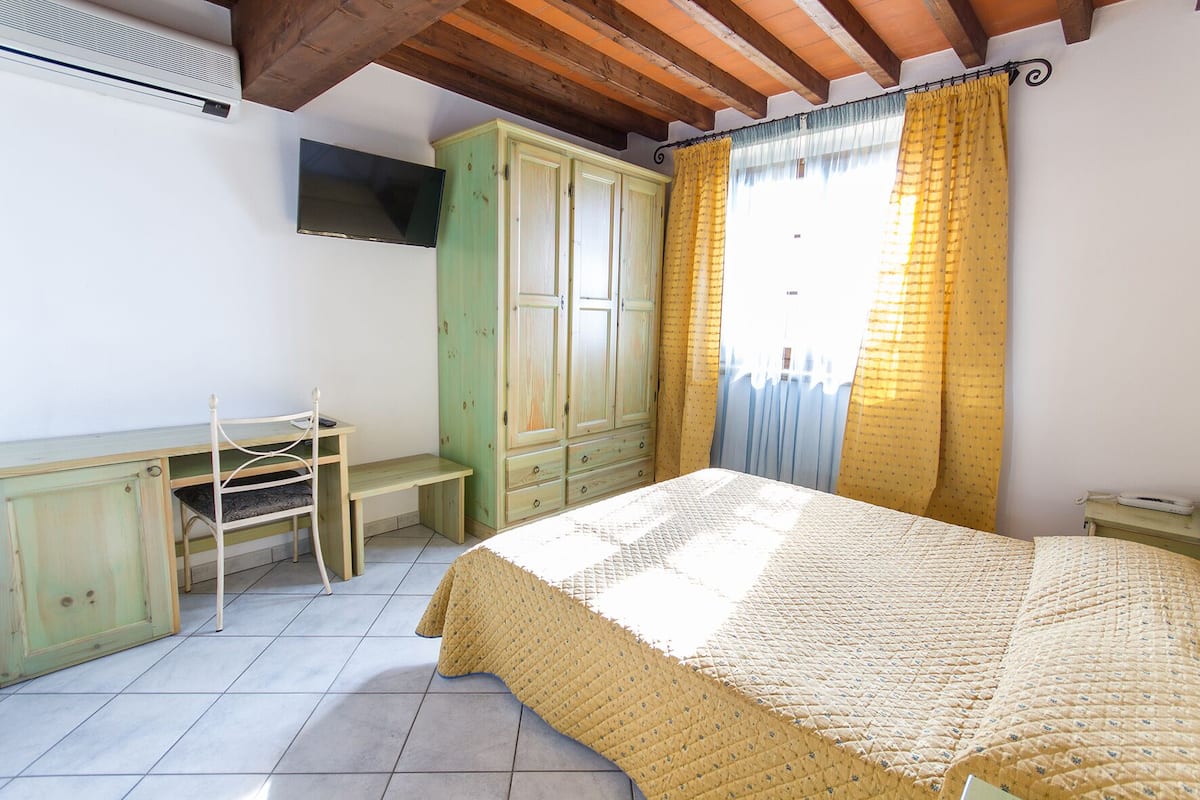 Un dormitorio con cama, escritorio y armario.