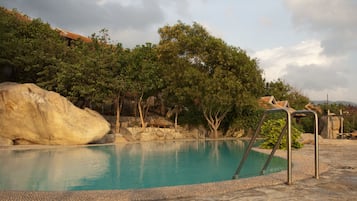 Alberca al aire libre y camastros