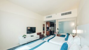 Une chambre d’hôtel avec un grand lit, une télévision, un bureau et une kitchenette.