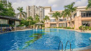 Una piscina rodeada de palmeras y edificios modernos.