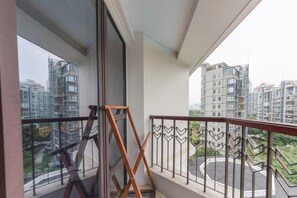 A balcony with a wooden ladder, metal railing, and a view of surrounding high-rise buildings. - Xiamen Zhongwei Gulangwan hotel (Xiamen)