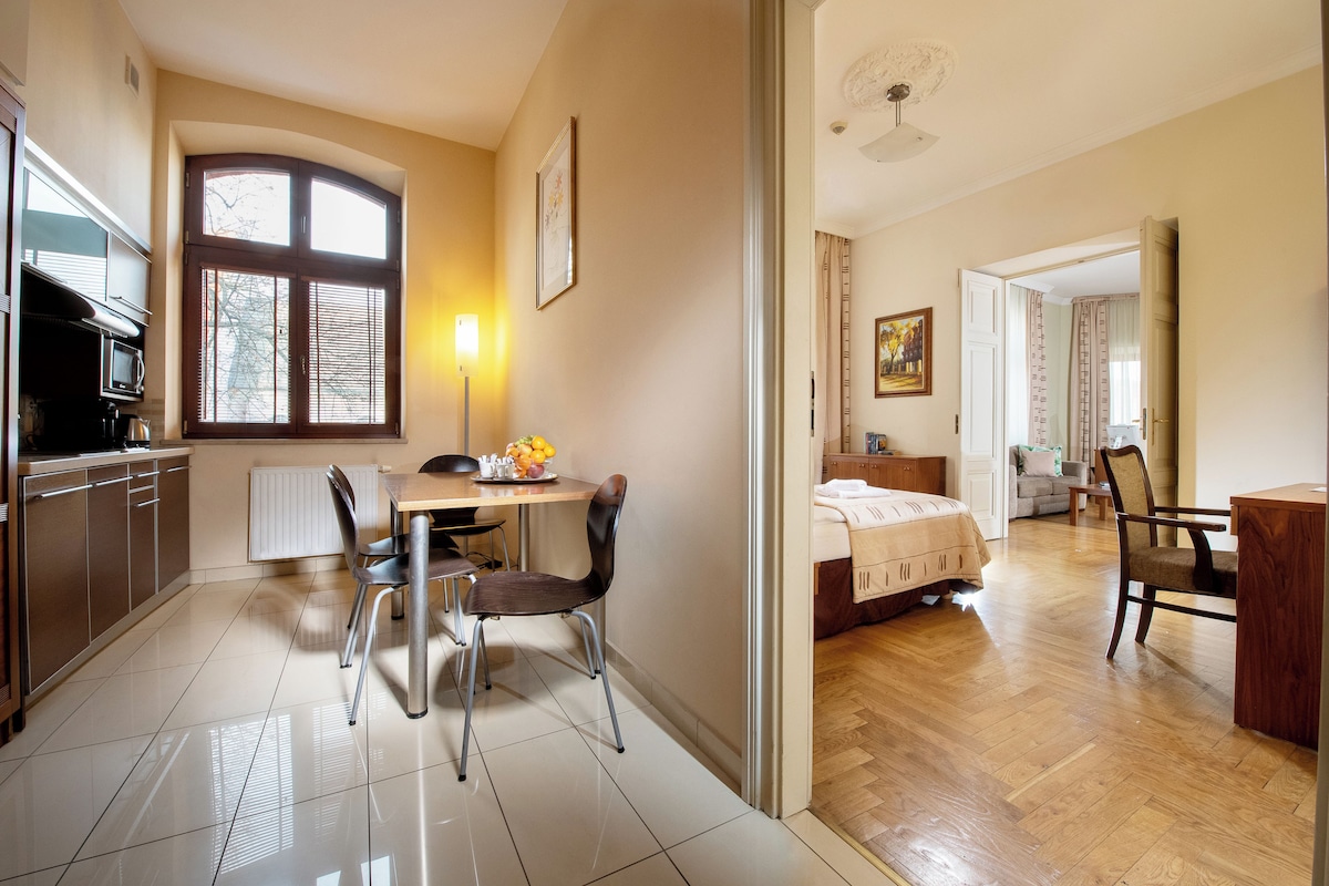 A well-lit kitchen with a dining area, a bed, and a living room with a sofa.